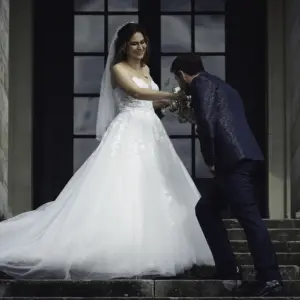 Hochzeitsfotograf Ulrich Roth – Bräutigam küsst Hand der Braut auf steinerner Treppe