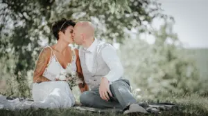 Brautpaar küsst sich unter Bäumen – natürliche Hochzeitsfotografie in der Pfalz