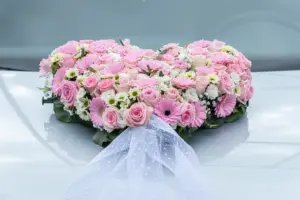 Herzförmiges Blumengesteck in Rosa auf dem Hochzeitsauto