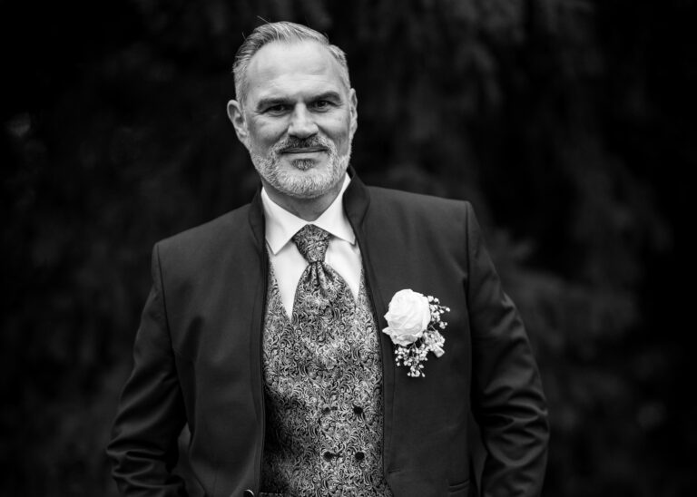 Bräutigam im eleganten Hochzeitsanzug – klassisches Schwarzweißporträt von Hochzeitsfotograf Ulrich Roth in der Pfalz