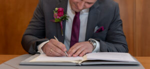 Bräutigam unterschreibt im Standesamt – Detailaufnahme Hochzeitsfotografie
